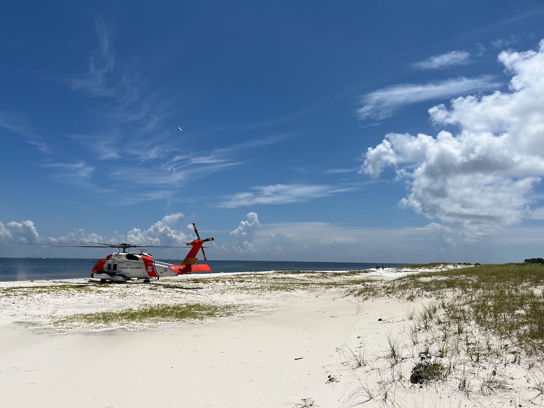 A Coast Guard Air Station New Orleans MH-60 Jayhawk helicopter sits on the beach July 29, 2024, on Horn Island, Mississippi. The aircrew was assisting in the rescue of 2 stranded boaters on the island. (U.S. Coast Guard video by Coast Guard Air Station New Orleans)