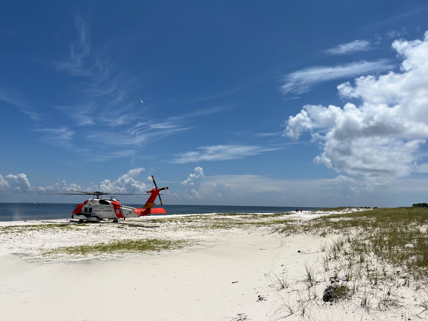 A Coast Guard Air Station New Orleans MH-60 Jayhawk helicopter sits on the beach July 29, 2024, on Horn Island, Mississippi. The aircrew was assisting in the rescue of 2 stranded boaters on the island. (U.S. Coast Guard video by Coast Guard Air Station New Orleans)