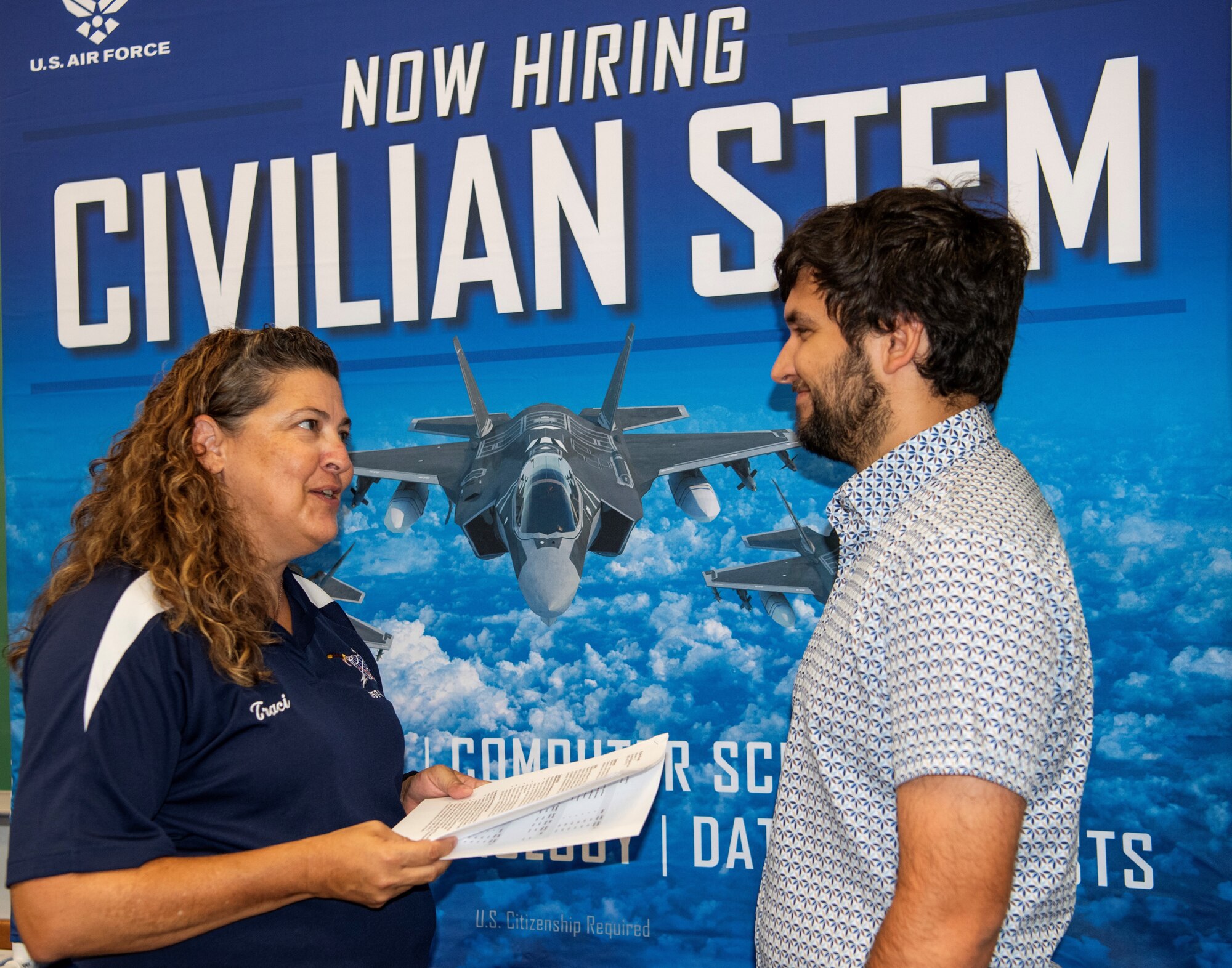 Two people in front of a sign that says civilian STEM