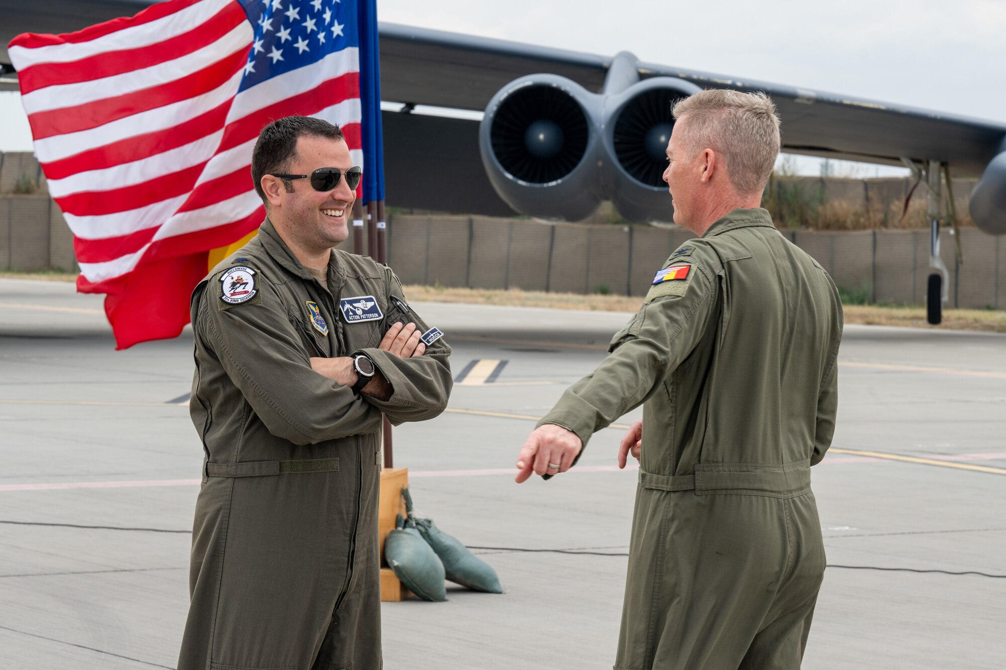 U.S. Air Force Lt. Col. Jared Patterson, 20th Expeditionary Bomb Squadron commander, and USAF Col. Keith Derbenwick, U.S. Embassy Defense Attache to Romania, have a quick chat before a media engagement at Mihail Kogălniceanu Air Base, Romania, during Bomber Task Force Deployment 24-4, July 23, 2024.