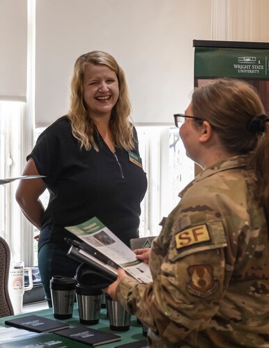 Kristina Healy, left, the Academic Services Director for Wright State University’s Raj Soin School of Business, interacts with an Airman during an education fair at Wright-Patterson Air Force Base, Ohio, July 24, 2024.