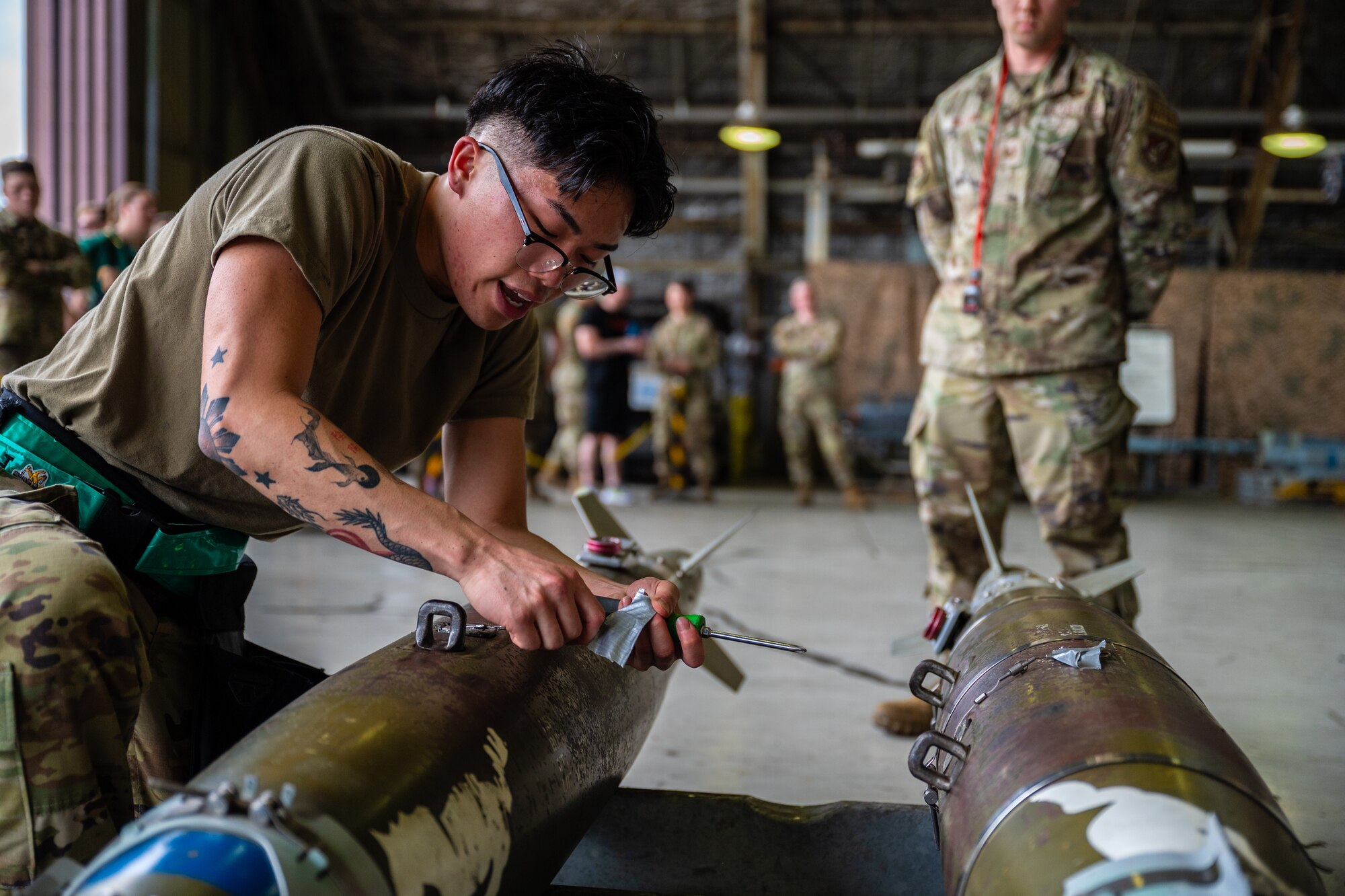 U.S. Air Force Airman 1st Class Jayden Patrick Ramirez, 25th Fighter Generation Squadron weapons load crew member, inspects an inert GBU-54 armament during the 2nd Quarter Load Crew Competition at Osan Air Base, Republic of Korea, July 26, 2024. The training helps build mutual trust and improves teamwork which is essential in executing missions with precision and cohesion. (U.S. Air Force photo by Staff Sgt. Christopher Tam)