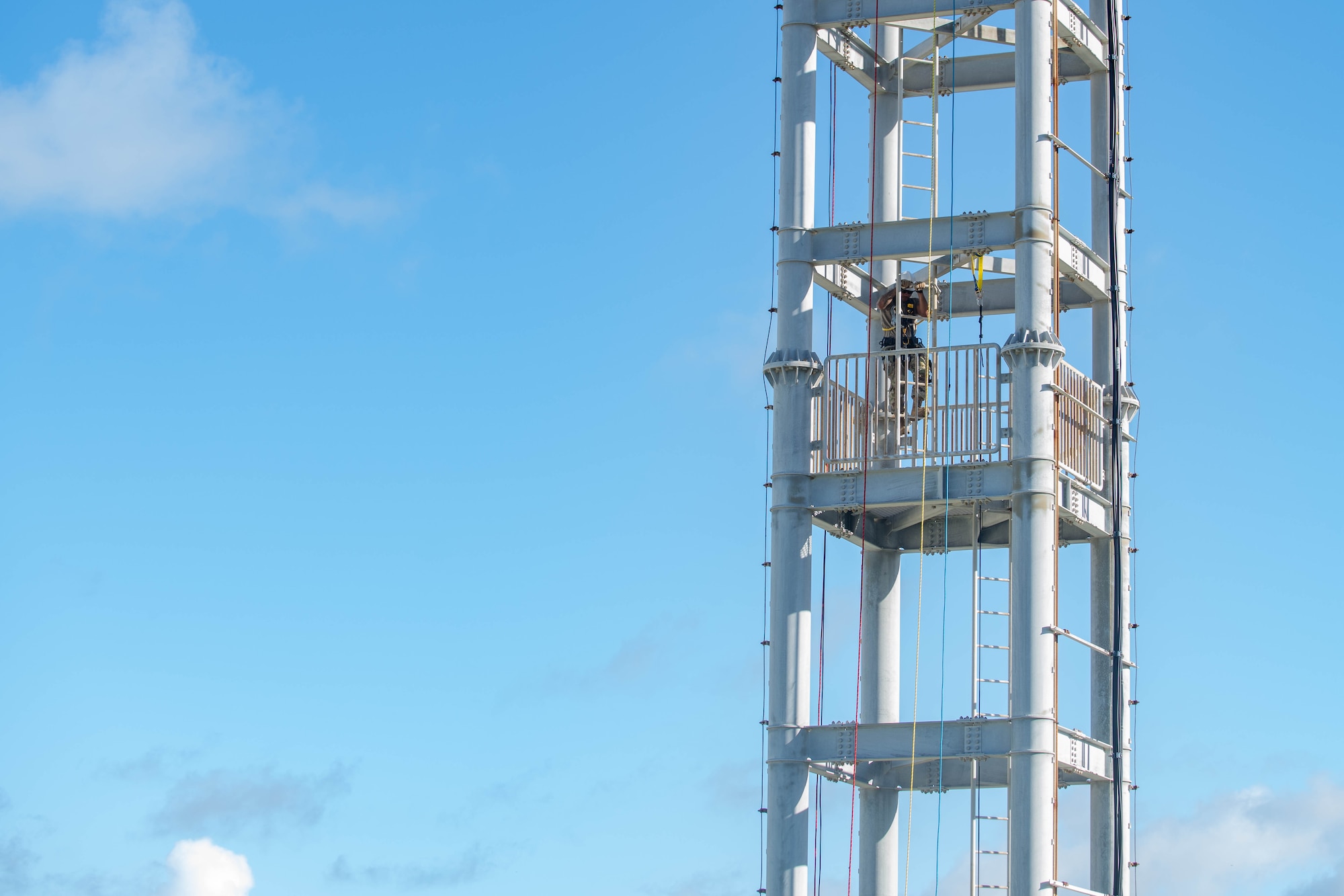military member climbs up a training tower ladder