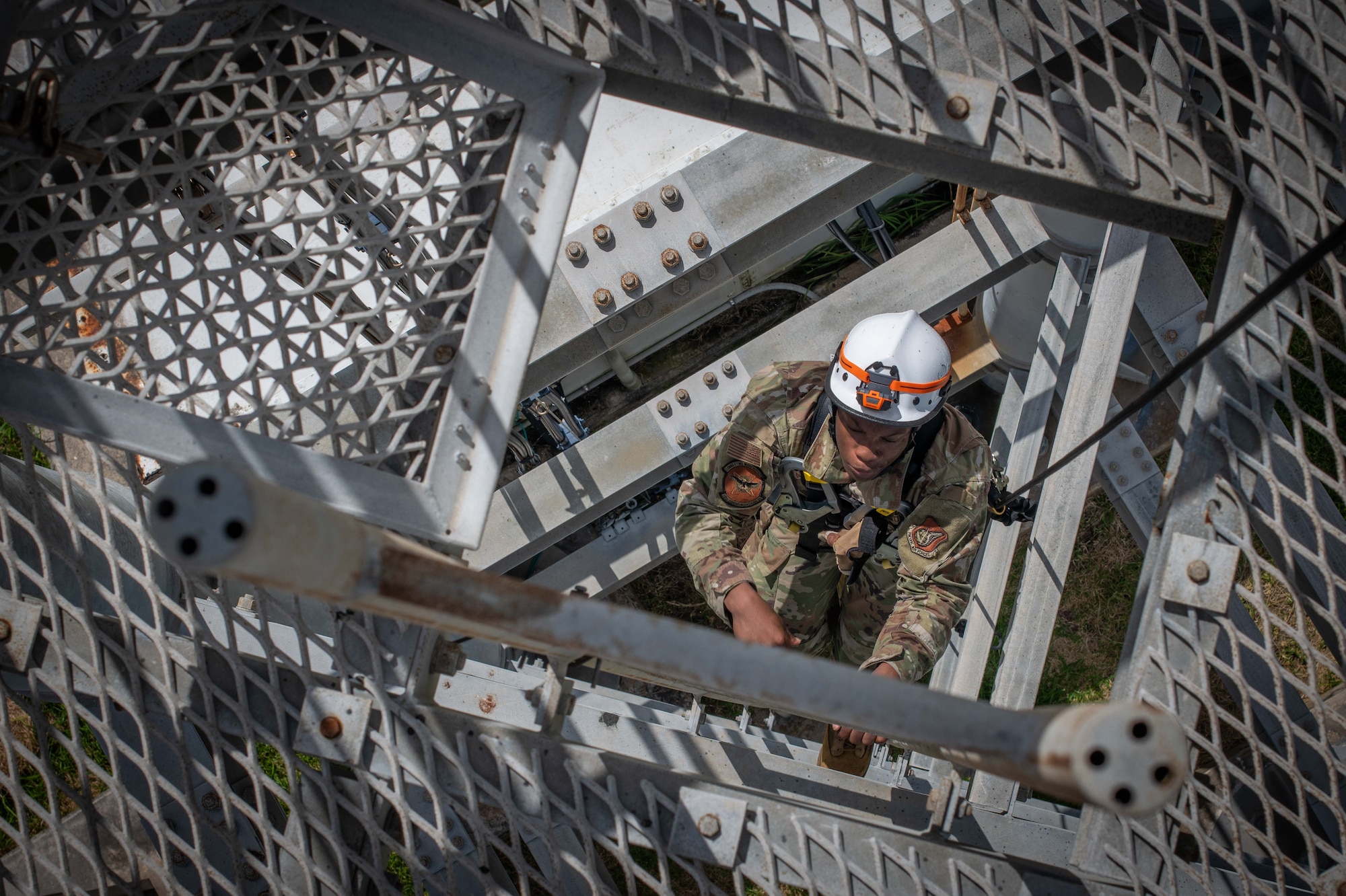 military member climbs up a training tower ladder