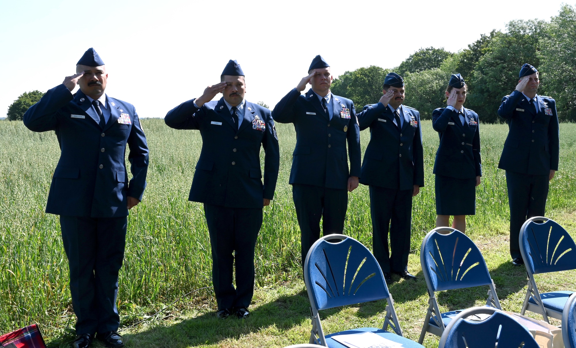 U.S. Air Force Airmen from Royal Air Force Mildenhall salute during the playing of the British and American national anthems at the start of a memorial ceremony held on the 80th anniversary of a B-17 Flying Fortress crash near Bury St. Edmunds, Suffolk, England, July 19, 2024. The B-17 – “Little Boy Blue” crashed in a farmer’s field July 19, 1944, after its fuselage was ripped in half after a collision with another aircraft on the way to a mission to bomb a ball-bearing factory in Schweinfurt, Germany. Only two of the crew survived. (U.S. Air Force photo by Karen Abeyasekere)