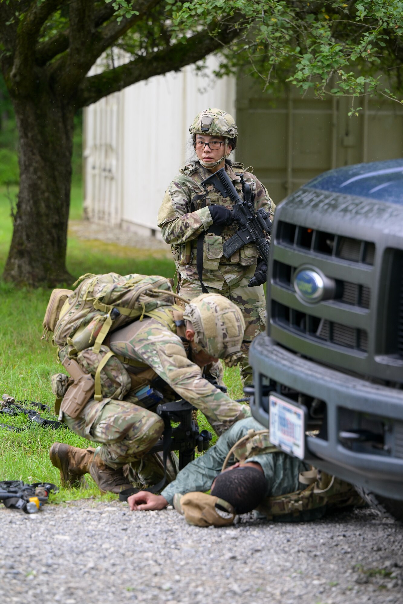 Integrated Defense Leadership Course student Master Sgt. Lek Indara watches the perimeter while Master Sgt. Kevin Walter searches an opposing force member for intel during an area security operations exercise at Camp James A. Garfield Joint Military Training Center, Ohio, July 25, 2024.