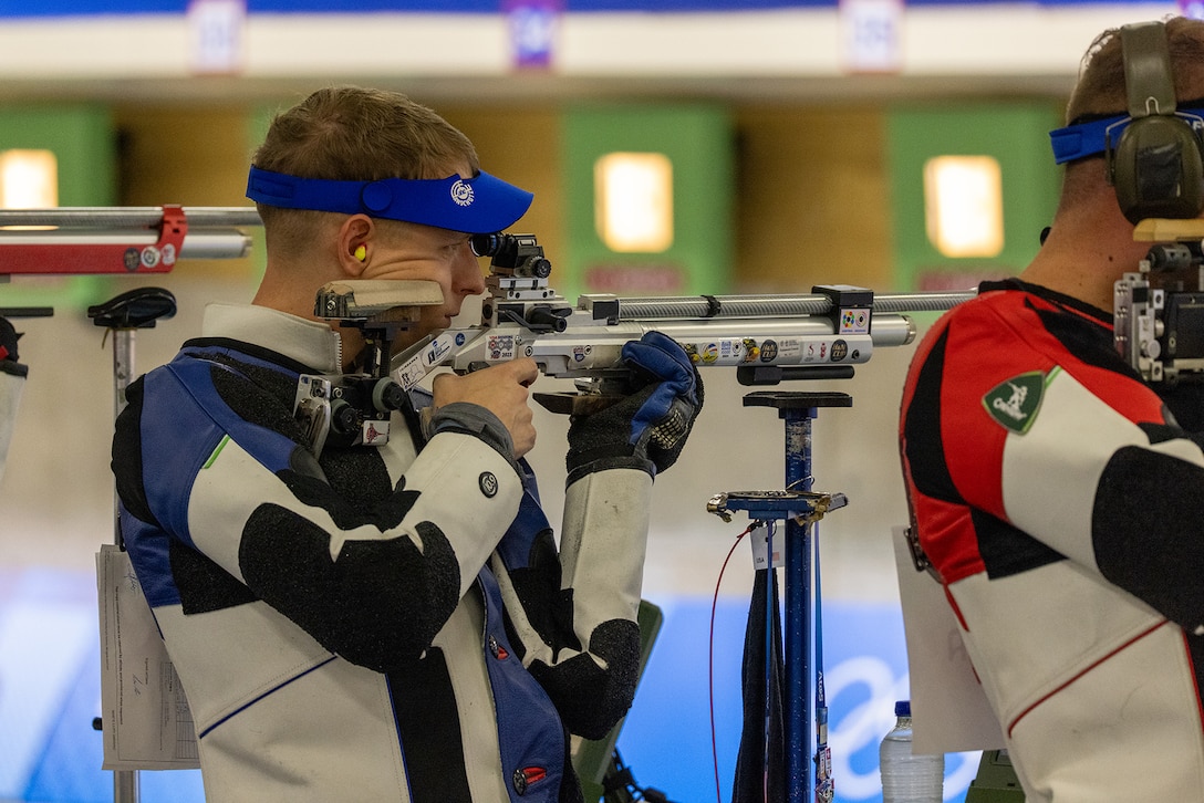 A soldier takes a shooting stance while using a cheek rest on a rifle during an Olympic marksmanship competition.