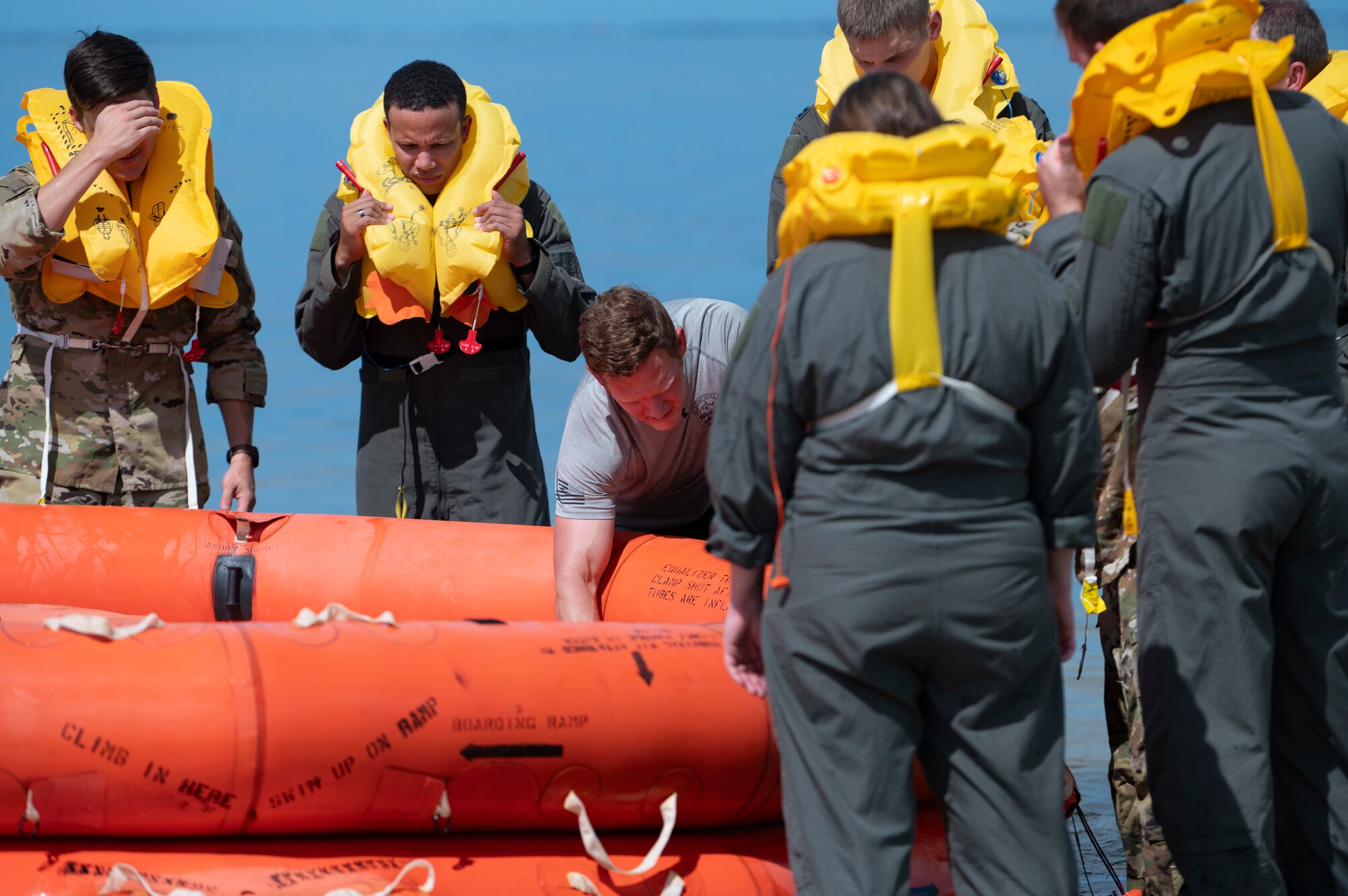 U.S. Air Force Tech. Sgt. Jeremy Haskins, a Survival, Evasion, Resistance and Escape specialist assigned to the 6th Operations Support Squadron, speaks to aircrew members about raft safety at MacDill Air Force Base, Florida, June 28, 2024. The aircrew members assigned to various units participated in a SERE water survival course to prepare them for in-flight emergencies. (U.S. Air Force photo by Airman 1st Class Alicia Campbell)