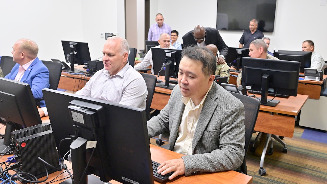 A team of professions working on computers in a classroom