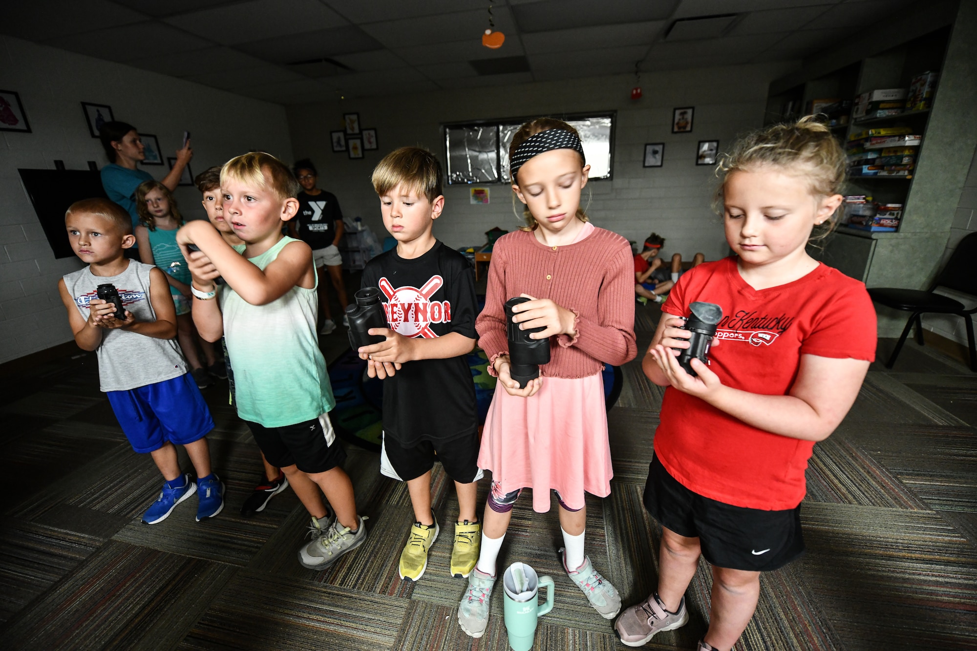 Children hold night vision scopes