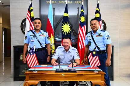 Senior enlisted leaders of the Washington Air National Guard and the Royal Malaysian Air Force pose for a photo while signing a guest book during a senior enlisted visit at Wisma Bintara Angkatan Tentera, Malaysia, July, 25, 2024.