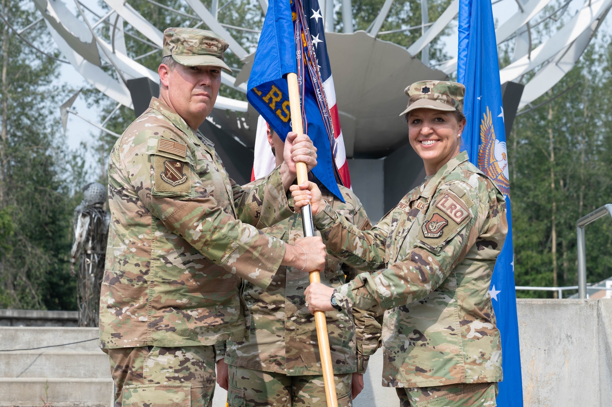 U.S. Air Force Col. Timothy Foster (left), 354th Mission Support Group commander, accepts the guidon from Lt. Col. Dawn Pieper, 354th Logistics Readiness Squadron outgoing commander, at the 354th LRS change of command ceremony at Eielson Air Force Base, Alaska, July 24, 2024.