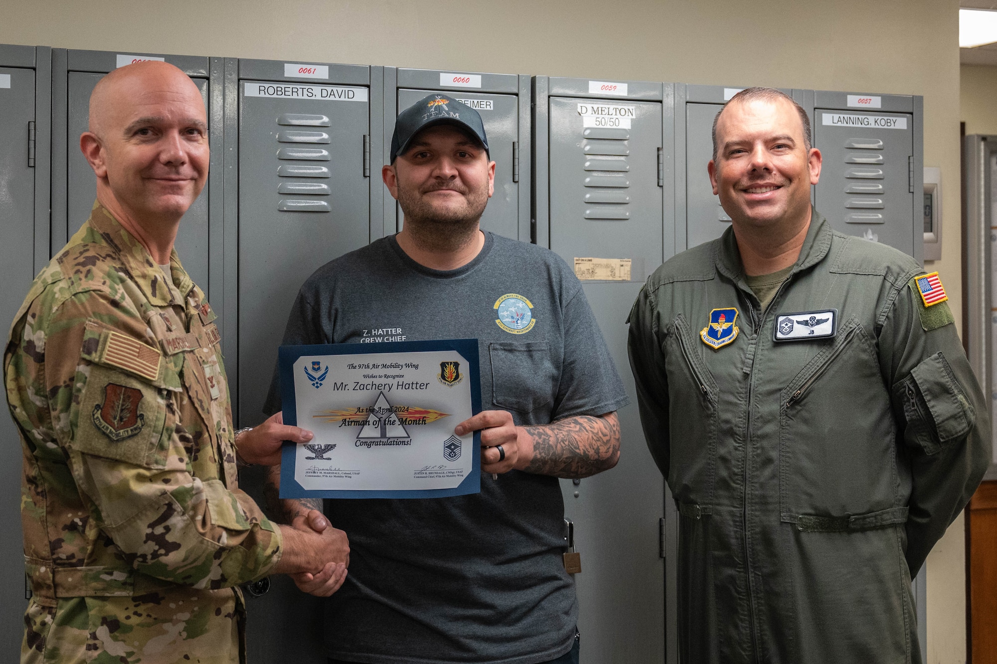 Zachary Hatter, 97th aircraft crew chief, center, is awarded the April Airman of the Month certificate by Col. Jeff Marshall, 97th Air Mobility Wing (AMW) commander, left, and Chief Master Sgt. Justin Brundage, 97th AMW command chief, right, at Altus Air Force Base Oklahoma, June 20, 2024. Hatter’s favorite aspects of his job are getting to work on the aircraft and supporting mission readiness.