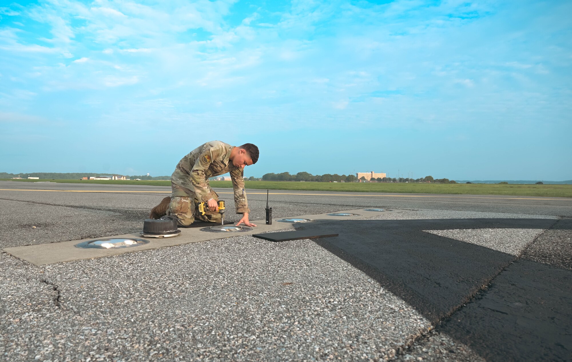 Airman fixing a light on the runway