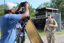 Soldier getting interviewed by film crew outside perimeter of a simulated Forward Operating Base