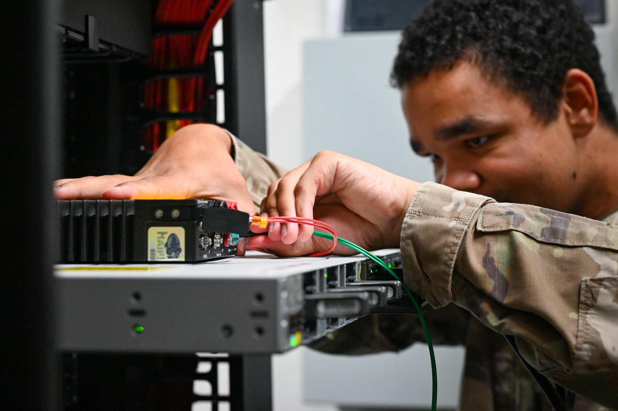 An Airman calibrates a network device.