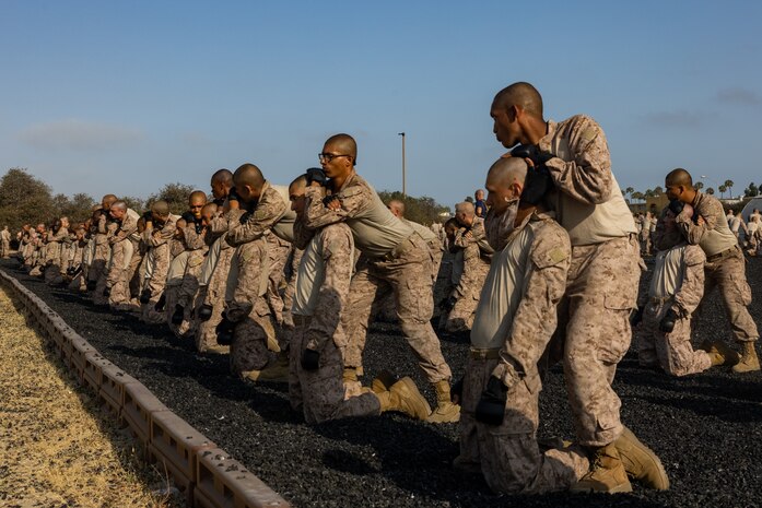 U.S. Marine Corps recruits with Kilo Company, 3rd Recruit Training Battalion, execute a rear choke hold during the Marine Corps Martial Arts Program test to earn their tan belts at Marine Corps Recruit Depot San Diego, July 25, 2024. Recruits performed various techniques to qualify for their tan belt in MCMAP. MCMAP aims to strengthen the mental and moral resiliency of individual Marines through realistic combative training and warrior ethos studies. (U.S. Marine Corps photo by Lance Cpl. Jacob B. Hutchinson)
