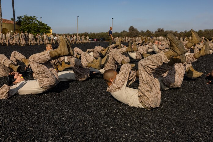U.S. Marine Corps recruits with Kilo Company, 3rd Recruit Training Battalion, execute back break falls during the Marine Corps Martial Arts Program test to ear their tan belts at Marine Corps Recruit Depot San Diego, July 25, 2024. Recruits performed various techniques to qualify for their tan belt in MCMAP. MCMAP teaches hand-to-hand combat techniques along with warrior ethos. (U.S. Marine Corps photo by Lance Cpl. Jacob B. Hutchinson)
