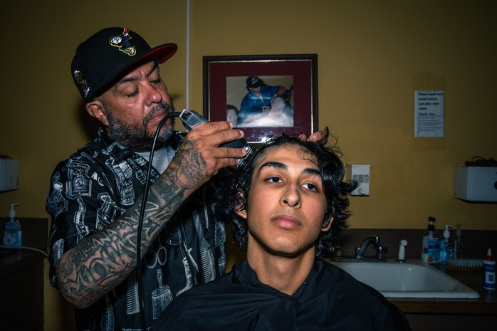 Mr. Felipe Garza, a barber for Marine Corps Recruit Depot San Diego, gives a recruit his initial haircut as a part of the receiving process at MCRD San Diego, California, July 25, 2024. During the receiving process, recruits are checked for contraband, given haircuts, make a scripted phone call home, and issued gear required for training. (U.S. Marine Corps photo by Cpl. Sarah M. Grawcock)