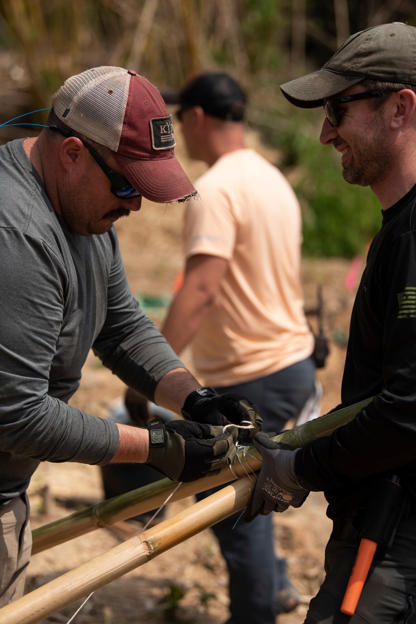 Two men smile while working.