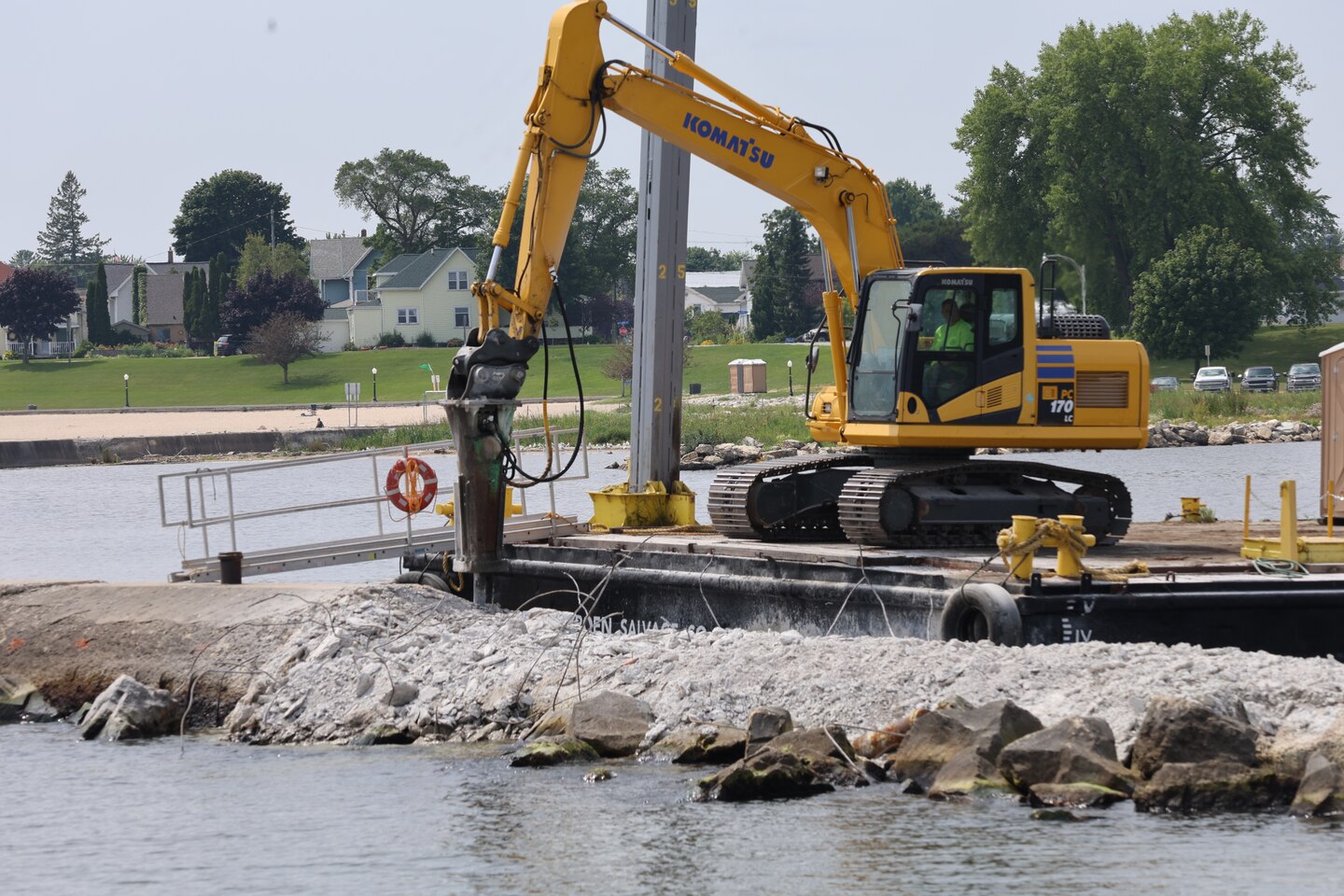 Construction equipment breaks apart concrete breakwater in Algoma Harbor so that a new wall can be reconstructed.