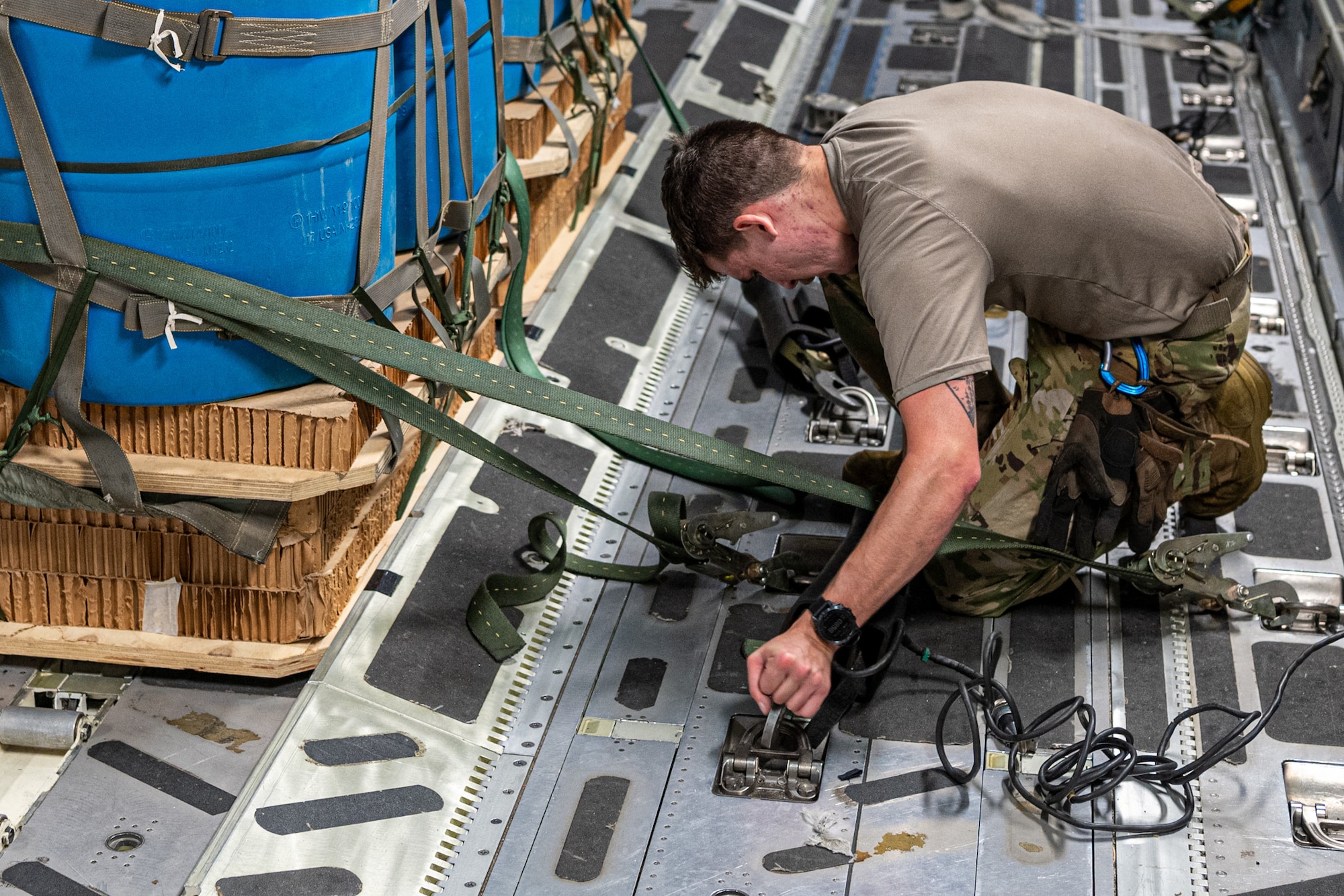 Senior Airman Brian Austin, 8th Airlift Squadron loadmaster, secures an airdrop pallet before takeoff at Joint Base Lewis-McChord, Washington, July 30, 2024. Loadmasters work closely with aerial port squadrons and others, to ensure the correct placement, security, and order of aircraft cargo. (U.S. Air Force photo by Airman 1st Class Benjamin Riddle)
