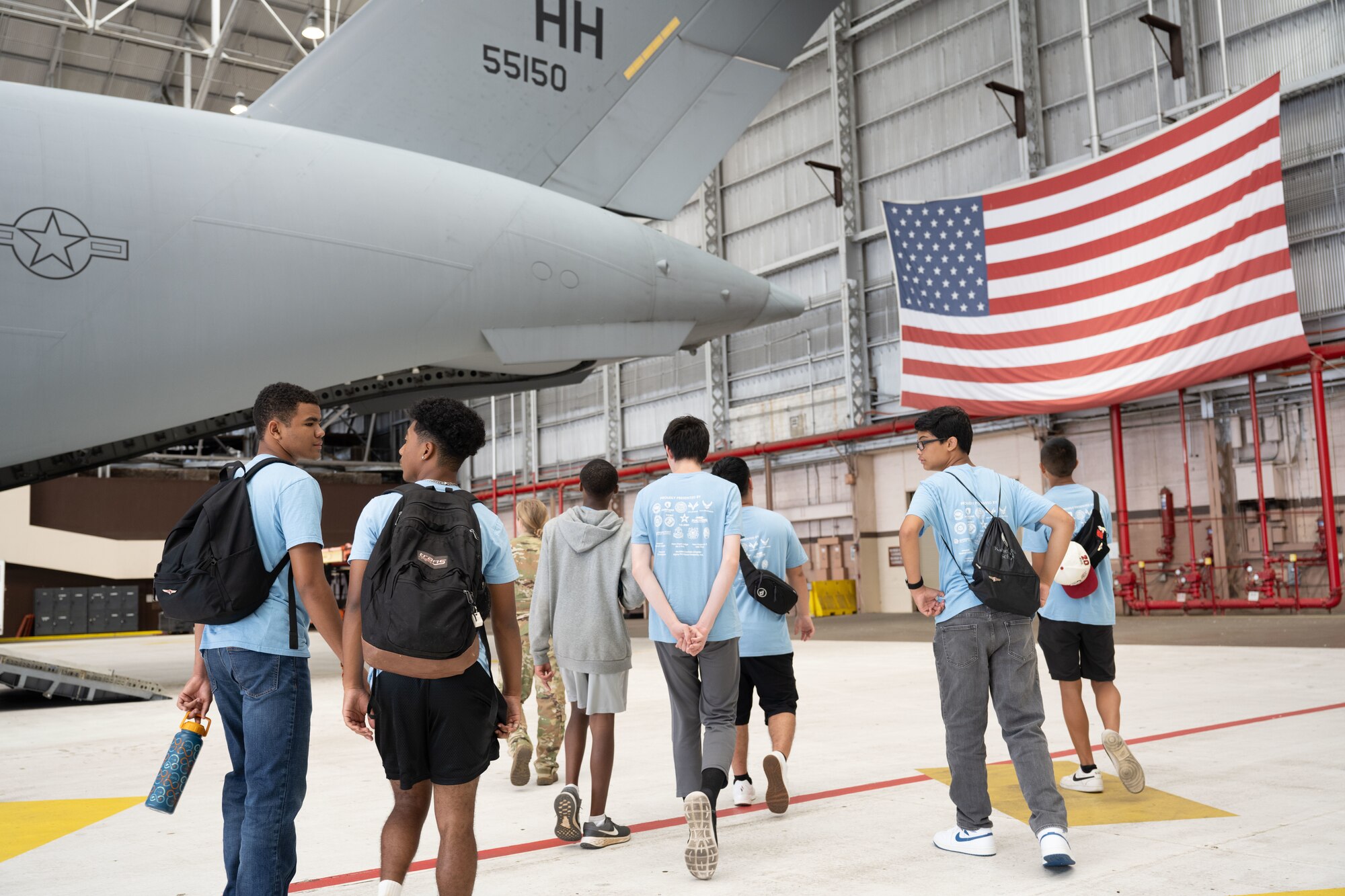 Students tour an aircraft in a hangar.