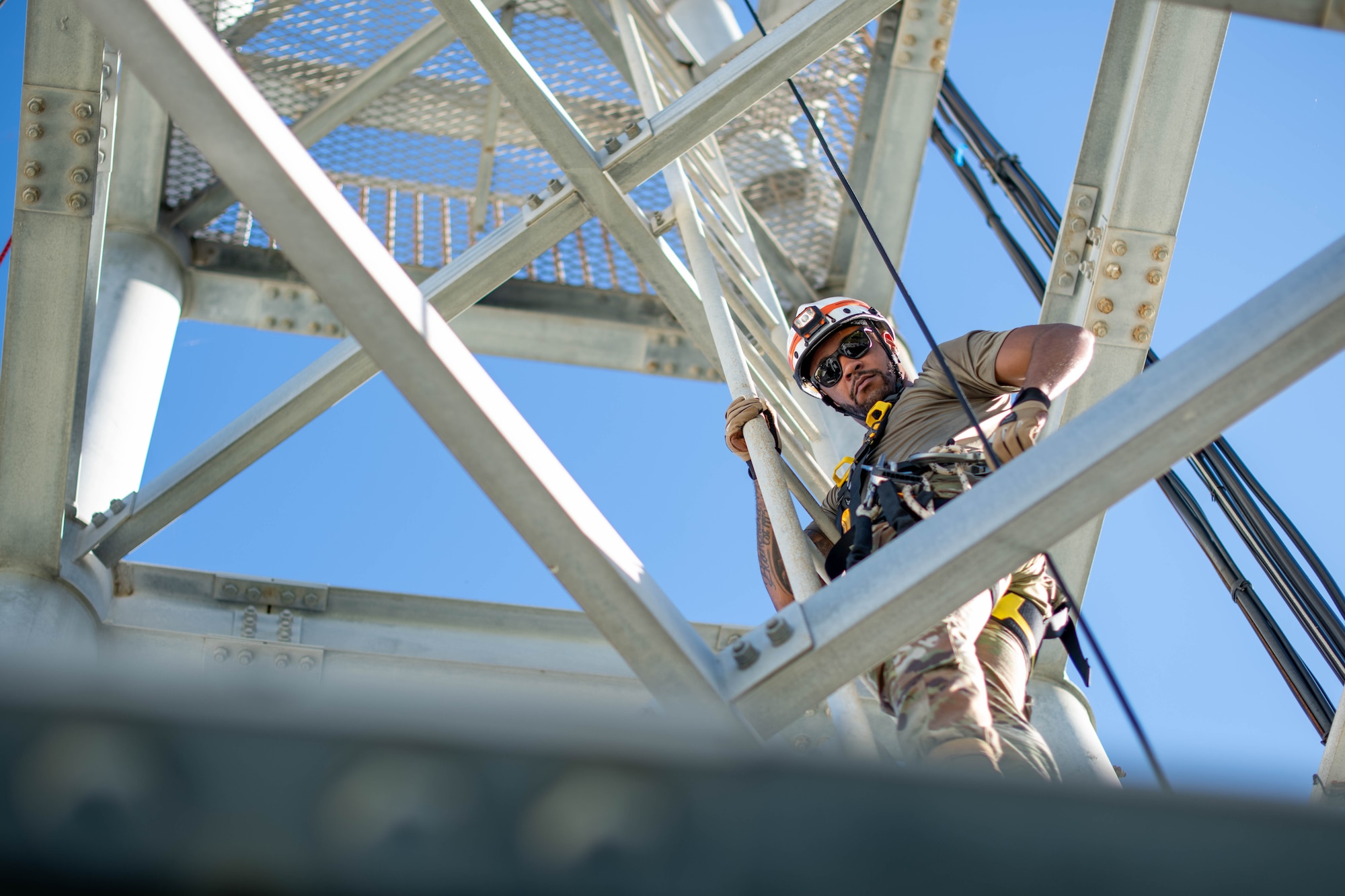military member climbs up a training tower ladder