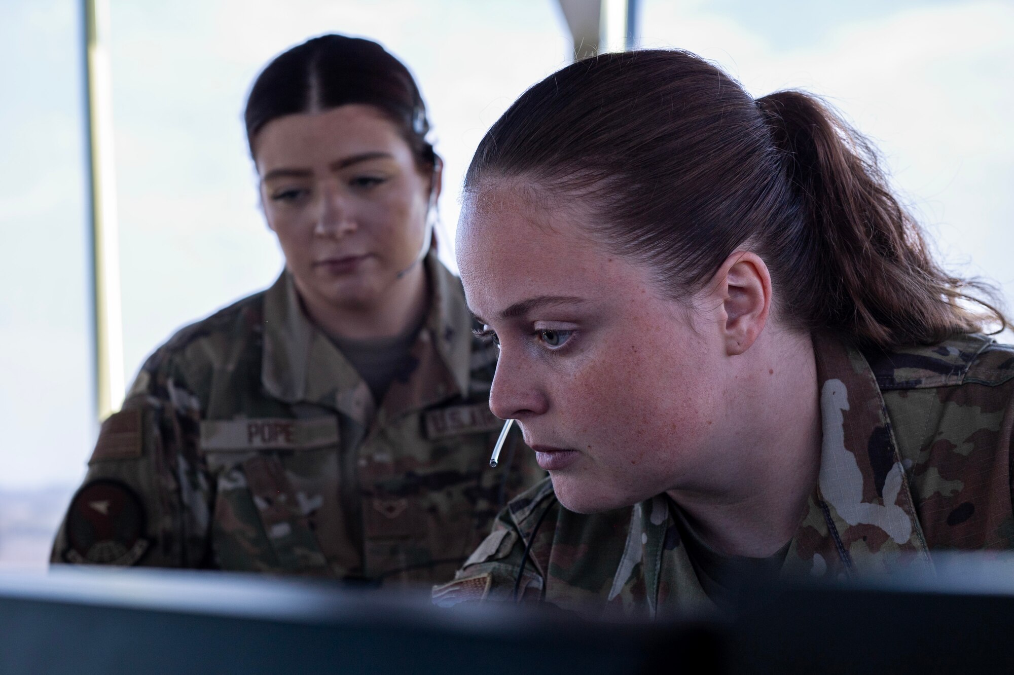Staff Sgt. Michaela Gundersen, a watch supervisor assigned to the 92nd Operations Support Squadron, teaches Airman Samantha Pope, an air traffic control specialist assigned to the 92nd OSS, how to correctly read the radar and locate aircraft at Fairchild Air Force Base, Washington, July 29, 2024. Learning to read the radar is essential for ATC specialist to provide a safe and orderly flow of aircraft. ATC specialists manage the flow of aircraft through all aspects of the flight, ensuring the safety and efficiency of air traffic on the ground and in the air. (U.S. Air Force photo by Senior Airman Morgan St Marks)