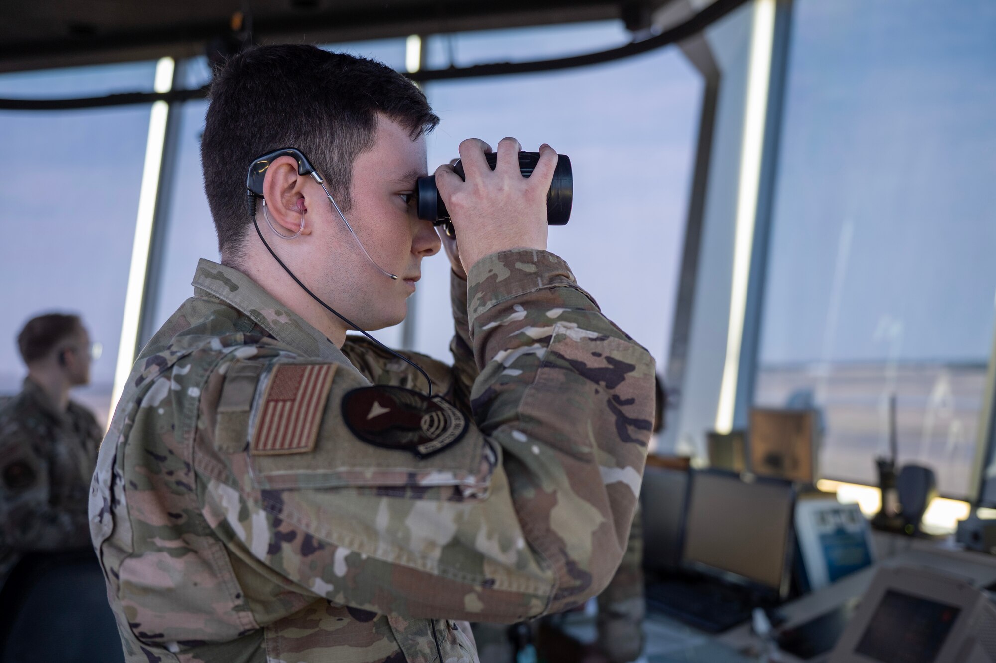 Senior Airman Andrew Huynh, an air traffic control specialist assigned to the 92nd Operations Support Squadron, monitors the flight line at Fairchild at Fairchild Air Force Base, Washington, July 29, 2024. Huynh used the binoculars to visually identify the location of a distant inbound aircraft. ATC specialists manage the flow of aircraft through all aspects of the flight, ensuring the safety and efficiency of air traffic on the ground and in the air. (U.S. Air Force photo by Senior Airman Morgan St Marks)