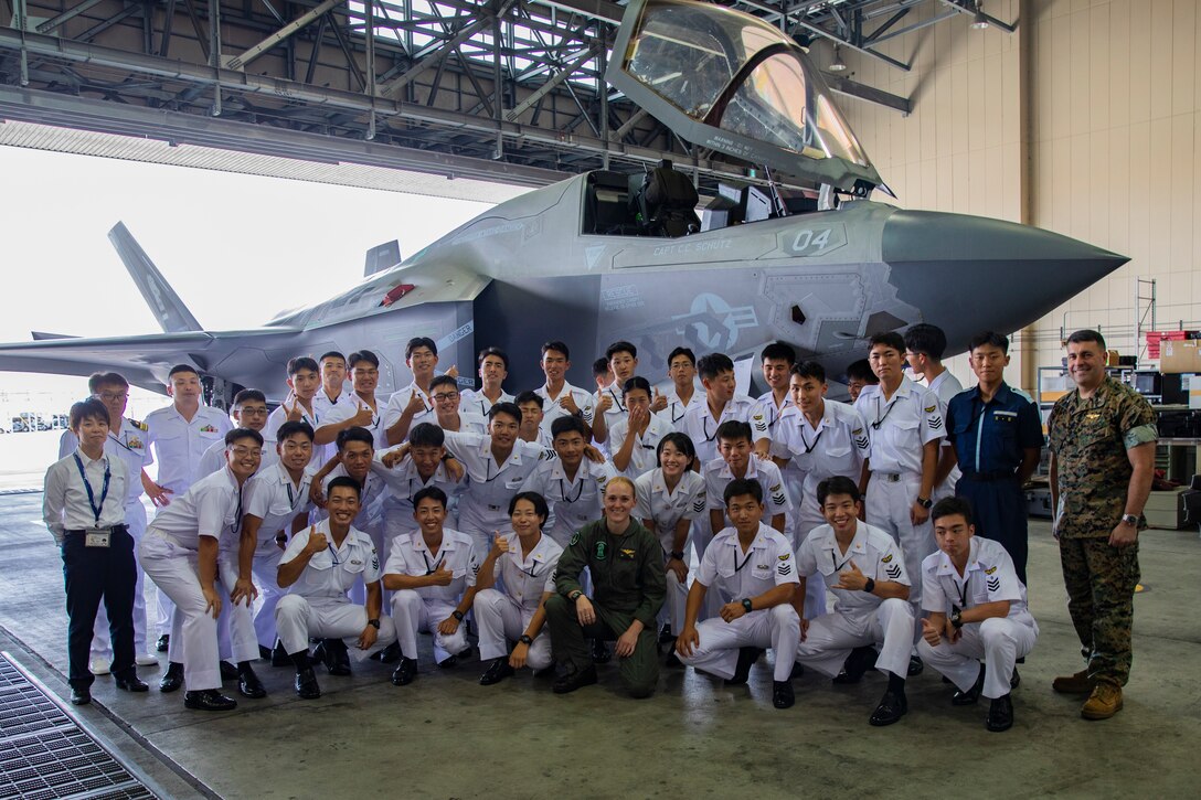U.S. Marines with Marine Corps Air Station Iwakuni, and Marine Fighter Attack Squadron 121, Marine Aircraft Group 12, 1st Marine Air Wing, pose for a group photo with Japan Maritime Self-Defense Force cadets in front of an U.S. Marine Corps F-35B Lightning II during an installation tour at MCAS Iwakuni, Japan, July 11, 2024. The tour gave JMSDF cadets an overview of the installation's capabilities and gave them an opportunity to see a number of aircraft, such as the F-35B Lightning II, KC-130J Super Hercules, and C-12 Huron. (U.S Marine Corps photo by Lance Cpl. Dahkareo Pritchett)
