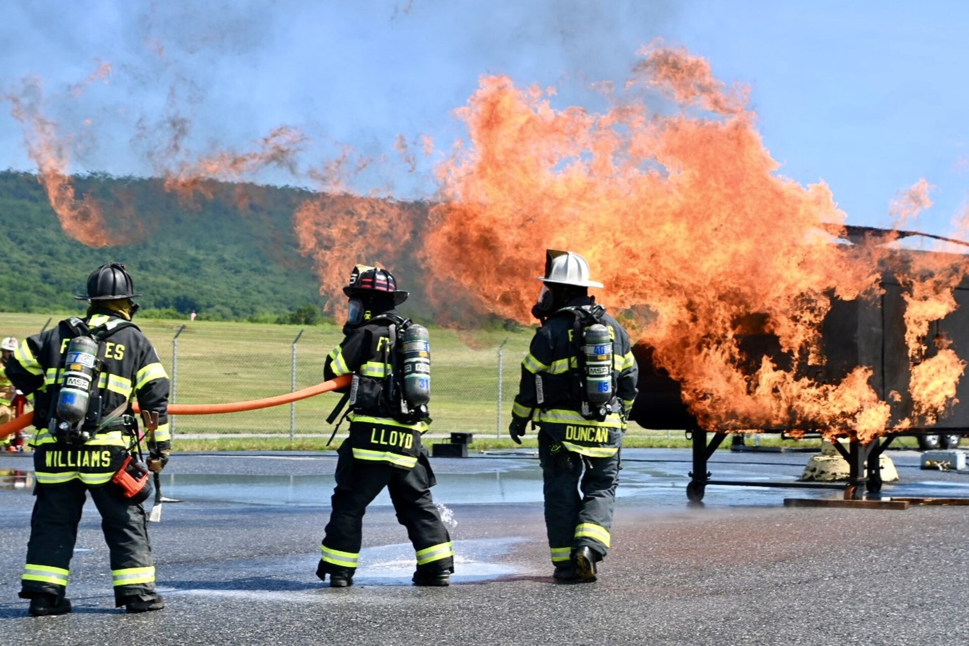 Firefighters with the Fort Indiantown Gap Fire Department train with their new Aircraft Rescue and Fire Fighting trainer across from the Fire Department building at Fort Indiantown Gap, Pennsylvania, July 26, 2024. This was the department's first time using this simulator, which helps them remain ready to save lives of personnel who work at Fort Indiantown Gap. (U.S. Army National Guard photo by Spc. Jessica Barb)