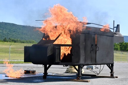 Firefighters with the Fort Indiantown Gap Fire Department train with their new Aircraft Rescue and Fire Fighting trainer across from the Fire Department building at Fort Indiantown Gap, Pennsylvania, July 26, 2024. This was the department's first time using this simulator, which helps them remain ready to save lives of personnel who work at Fort Indiantown Gap. (U.S. Army National Guard photo by Spc. Jessica Barb)