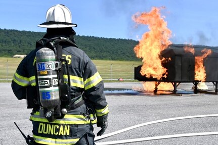 Firefighters with the Fort Indiantown Gap Fire Department train with their new Aircraft Rescue and Fire Fighting trainer across from the Fire Department building at Fort Indiantown Gap, Pennsylvania, July 26, 2024. This was the department's first time using this simulator, which helps them remain ready to save lives of personnel who work at Fort Indiantown Gap. (U.S. Army National Guard photo by Spc. Jessica Barb)