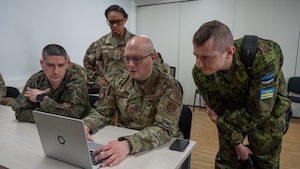 Maryland Air National Guard Maj. Artur Meryamov, 175th Cyberspace Operations Squadron, and Maryland Air National Guard Capt. Alexis Eyo, 275th Operations Support Squadron, work together with cyber defenders from Estonian Defense Forces Cyber Command and Poland Cyber Command to emulate an adversarial cyber threat in a simulated network as part of red team operations during the DEFENDER 24 cyber exercise, May 16, 2024, in Tallinn, Estonia.