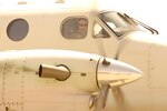 A pilot peers from a cockpit window.
