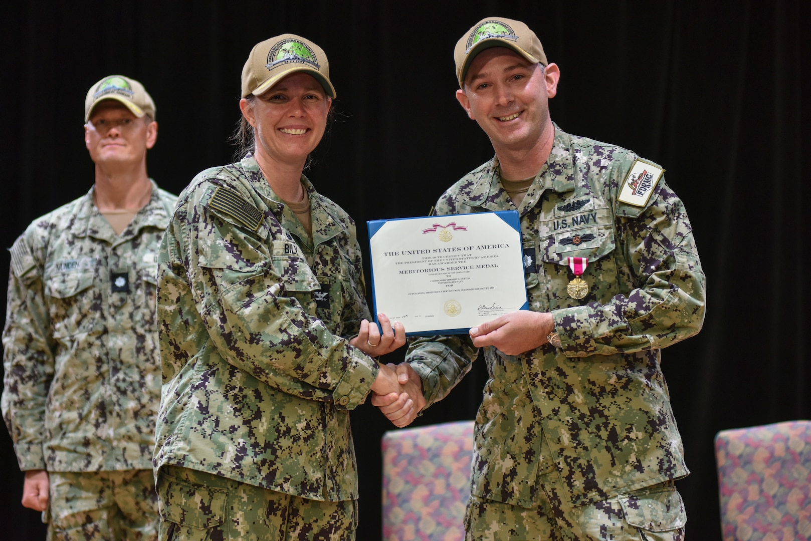 Cmdr. Timothy Dutton receives an end of tour award from Capt. Mollie Bily, commanding officer of Forward Deployed Regional Maintenance Center (FDRMC), during a change of charge ceremony held onboard U.S. Naval Support Activity Bahrain, July 25, 2024.