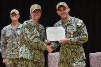 Cmdr. Timothy Dutton receives an end of tour award from Capt. Mollie Bily, commanding officer of Forward Deployed Regional Maintenance Center (FDRMC), during a change of charge ceremony held onboard U.S. Naval Support Activity Bahrain, July 25, 2024.