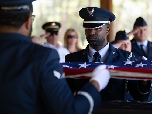 Senior Airman Hector Morales Pizarro, ceremonial guardsman, holds the American flag tightly during a flag folding at a Team Eglin Honor Guard Graduation ceremony.