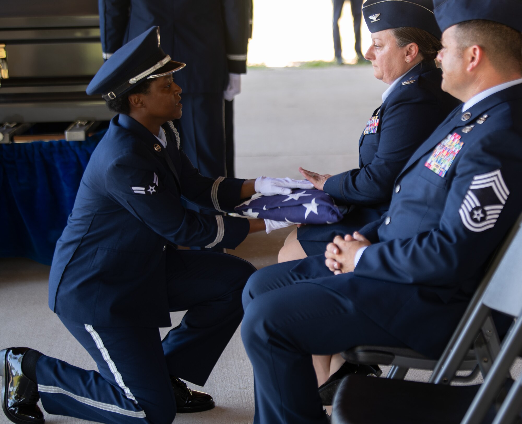 Airman 1st Class Bobbie Mills, Ceremonial Guardsman, hands the flag to Col. Tassika Davis, 96th Mission Support Group commander, during the Team Eglin Honor Guard Graduation ceremony.