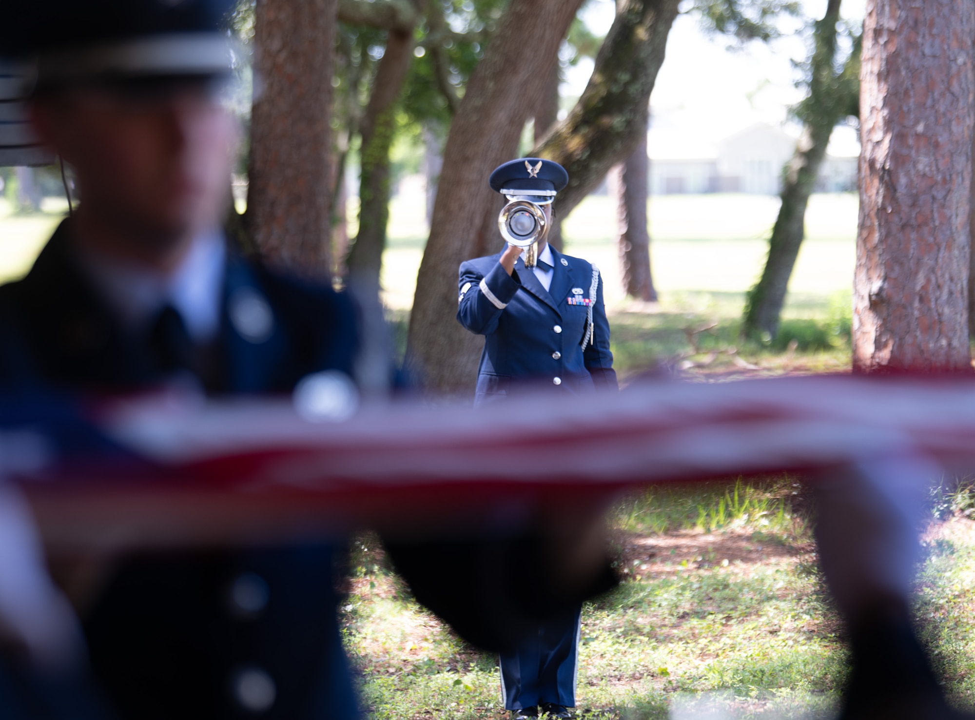 Senior Airman Mykleen Spears, ceremonial guardsman, holds the bugle as Taps plays during a full-honors funeral demonstration at the Team Eglin Honor Guard Graduation ceremony.