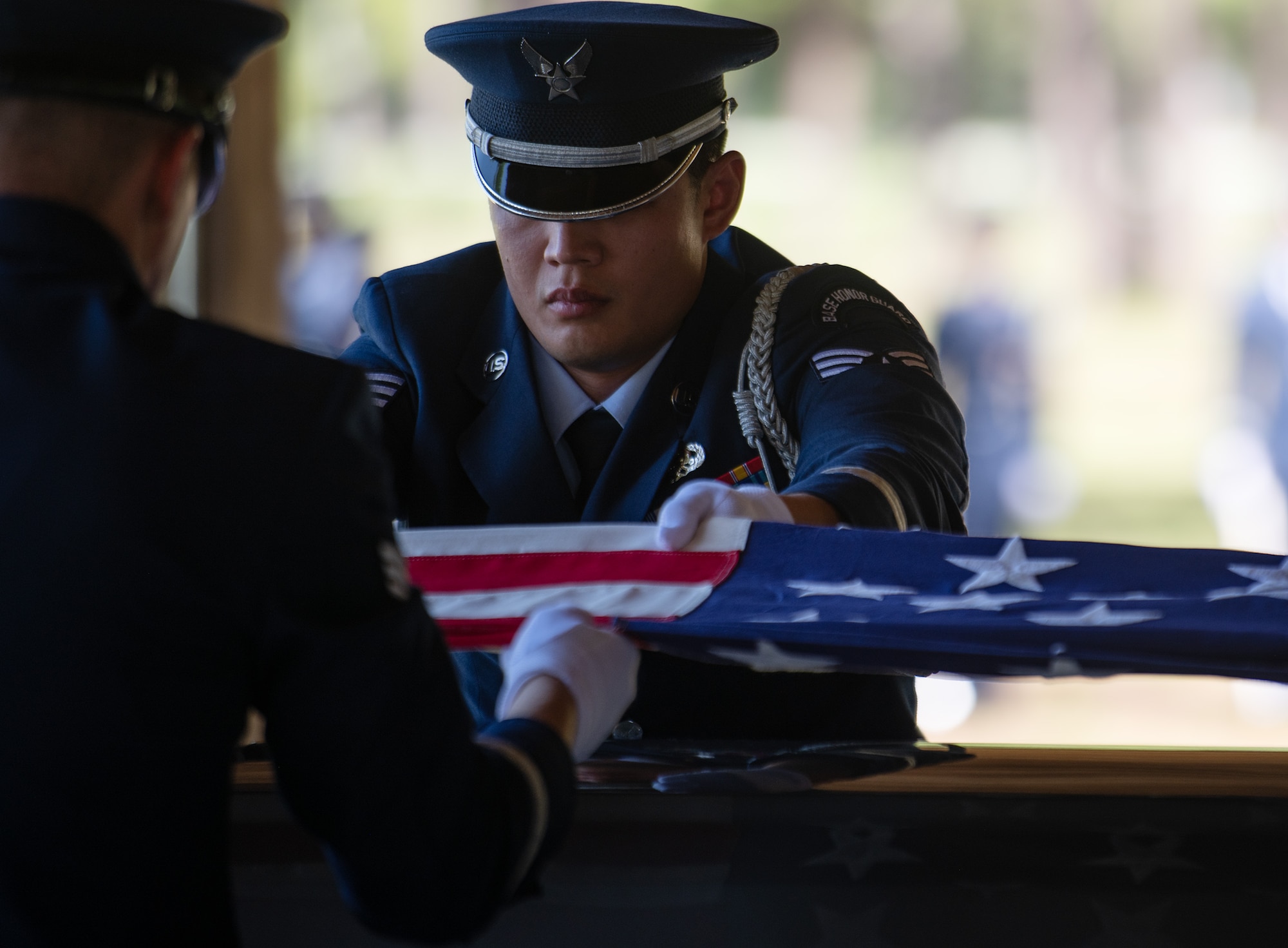 Senior Airman Matthew Michaud, ceremonial guardsman, holds the American flag tightly as it is folded during the Team Eglin Honor Guard Graduation ceremony.