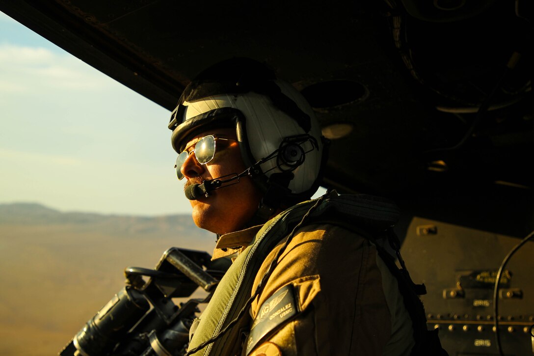 U.S. Marine Corps Lance Cpl. Carlos Gonzalez, an Arlington, Virginia native and crew chief with Marine Light Attack Helicopter Squadron 169, uses terrain features to find targets during a Fire Support Coordination Exercise as part of Service Level Training Exercise (SLTE) 5-24 at Marine Corps Air-Ground Combat Center, Twentynine Palms, California, July 23, 2024. The purpose of SLTE 5-24 is to create a challenging, realistic training environment that produces combat-ready forces capable of operating as an integrated Marine Air Ground Task Force. (U.S. Marine Corps photo by Lance Cpl. Weston Lindstrom)