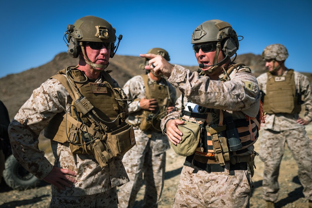 U.S. Marine Corps Gen. Eric M. Smith, left, the 39th Commandant of the Marine Corps, speaks with Chief Warrant Officer 4 Jordan Taylor, right, a gunner with Tactical Training and Exercise Control Group, during a platoon live-fire event held by 1st Battalion, 2d Marine Regiment, 2d Marine Division as part of Service Level Training Exercise (SLTE) 5-24 at Marine Corps Air-Ground Combat Center, Twentynine Palms, California, July 23, 2024. The purpose of SLTE 5-24 is to create a challenging, realistic training environment that produces combat-ready forces capable of operating as an integrated Marine Air Ground Task Force. (U.S. Marine Corps photo by Cpl. Alexis Sanchez)