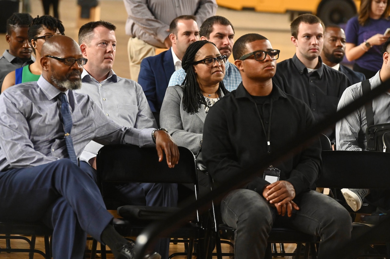 People in civilian clothes sit in a group.