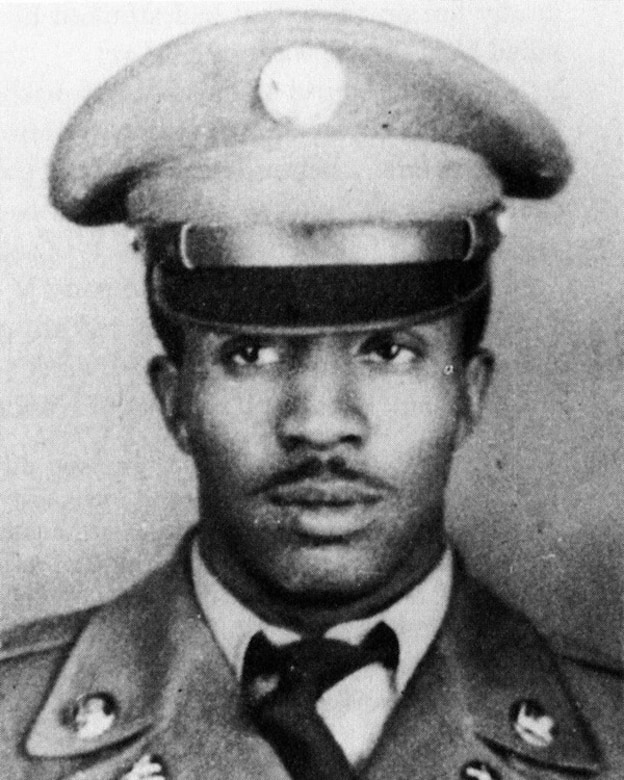 A man in military uniform poses for a photo taken from shoulder head length.