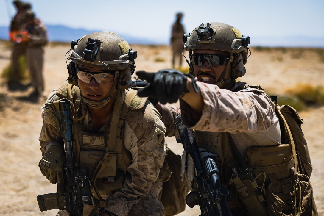 U.S. Marine Corps Lance Cpl. Michael Segaye, left, a Shiprock, New Mexico native and combat engineer with 2d Combat Engineer Battalion, 2d Marine Division, receives commands from Staff Sgt. Jordan Taylor, right, a Temple, Texas native and squad leader with 1st Battalion, 2d Marine Regiment, 2d Marine Division during a platoon live-fire event on range 205 as part of Service Level Training Exercise (SLTE) 5-24 at Marine Corps Air-Ground Combat Center, Twentynine Palms, California, July 22, 2024. The purpose of SLTE 5-24 is to create a challenging, realistic training environment that produces combat-ready forces capable of operating as an integrated Marine Air Ground Task Force. (U.S. Marine Corps photo by Cpl. Alexis Sanchez)