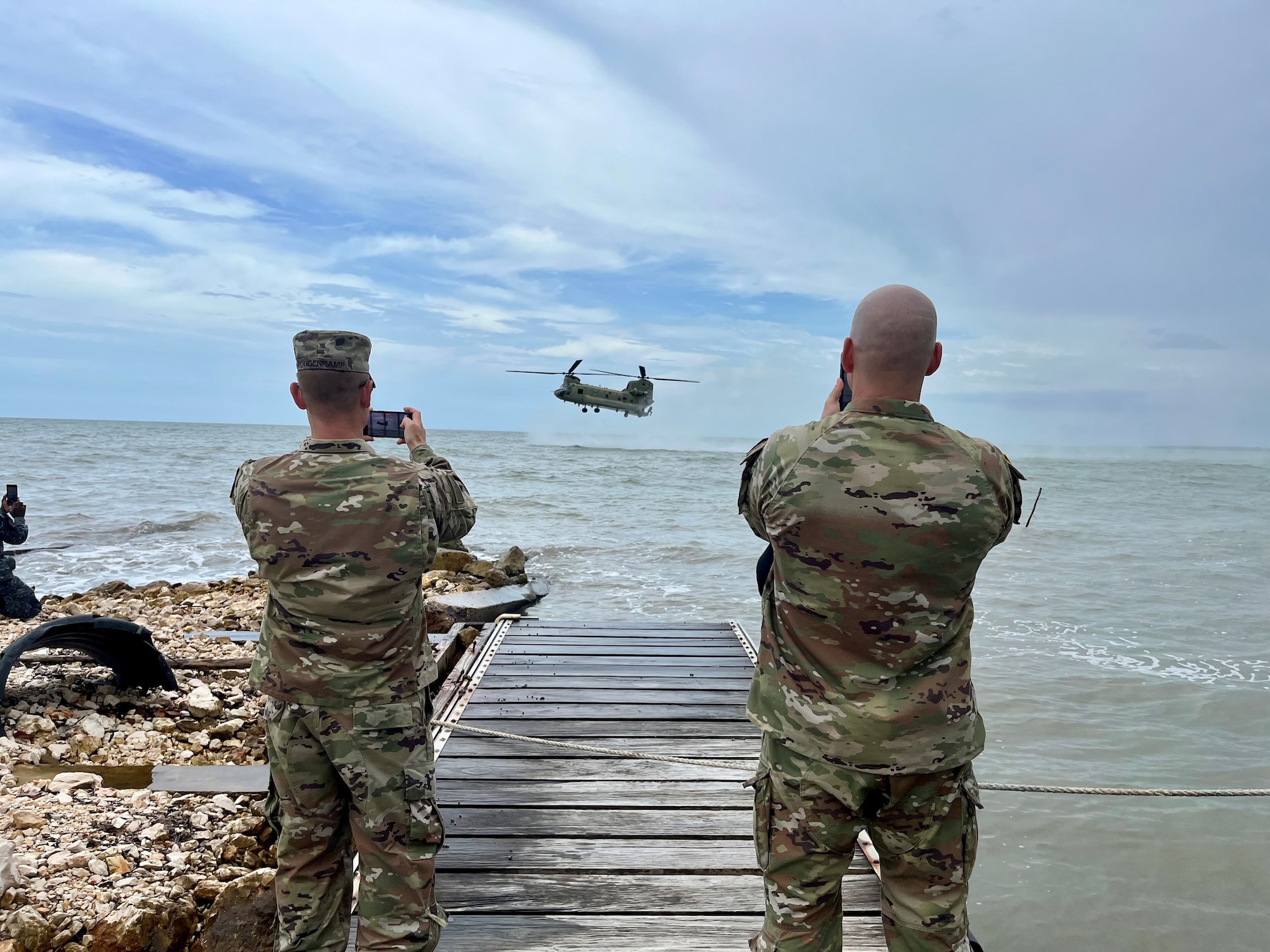 A photo of Soldiers taking a photo of a helicopter.