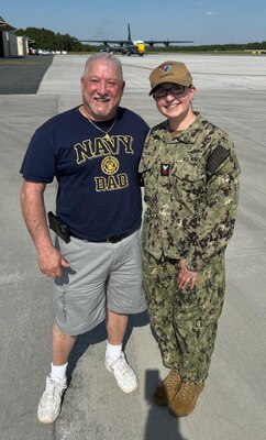 Navy Intelligence Specialist 1st Class Petty Officer Sarah Redsicker, right, a native of Chili, New York and assigned as a Cyber Threat Intelligence (CTI) analyst for Naval Information Warfare Center (NIWC) Atlantic’s Cybersecurity Service Provider (CSSP) team based in Charleston, South Carolina, poses with her dad, Robert Redsicker, following her reenlistment ceremony April 25 aboard the U.S. Navy Blue Angels’ iconic “Fat Albert” C-130. Robert traveled from Chili, New York to watch his daughter fly in “Fat Albert” from the ground.  Redsicker reaffirmed her oath to support and defend the Constitution of the United States for another three years in the Navy Reserve.