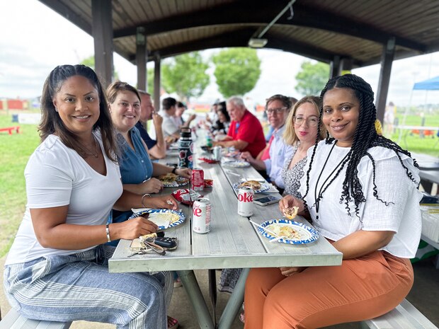 JOINT BASE ANACOSTIA-BOLLING, Washington, D.C. (July 30, 2024) - Employees enjoy a meal and socialize during  Strategic Systems Programs' (SSP) annual command picnic, Tuesday. This year's event for SSP staff and their families included food, games, a dunk tank, and the car show which featured vehicles--old and new--owned by members of the SSP workforce. The picnic was organized by SSP’s Activity and Recreations Committee (SPARC), an all-volunteer team made up of military and civilians who fundraise and plan MWR events throughout the year. SSP is the Navy command that provides cradle-to-grave lifecycle support for the sea-based leg of the nation’s nuclear triad. (U.S. Navy Photo by Lt. Jennifer Bowman/Released)